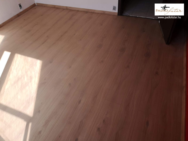 Egy meleg színű laminált padló illik a fa bútorokhoz.