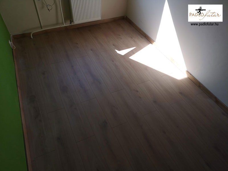 A meleg színű laminált padló a valósághű fa csomóival.